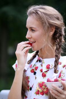 Portrait of the beautiful girl with a strawberry