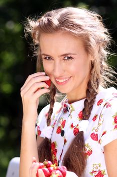 Portrait of the beautiful girl with a strawberry