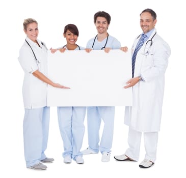 Group of doctors presenting empty board. Isolated on white