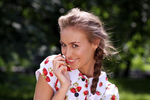 Portrait of the beautiful girl with a strawberry