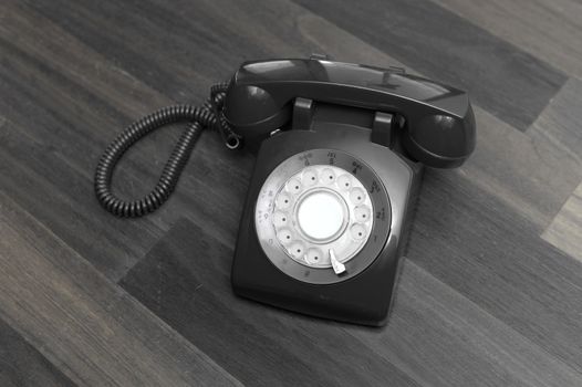 A vintage telephone isolated on a wooden floor