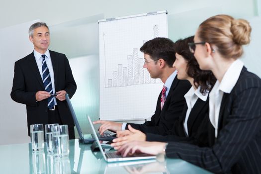 Cropped view image of a row of businesspeople working on laptops and tablets during a presentation or meeting