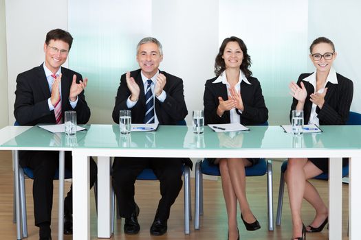 Group of corporate recruitment officers interviewing for a professional vacancy applauding