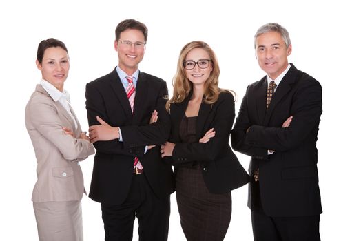 Smiling group of stylish business professionals standing in a row with their arms folded looking at the camera isolated on white