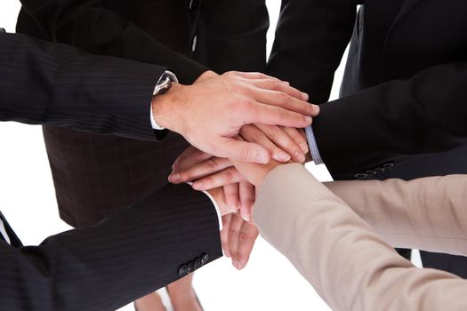 Group of four diverse businesspeople standing in a circle facing each other holding hands in a team