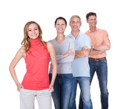 Four middle-aged attractive business associates or friends dressed in casual clothes standing in an oblique line