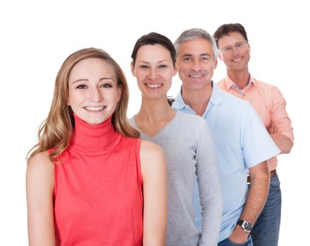 Four middle-aged attractive business associates or friends dressed in casual clothes standing in an oblique line