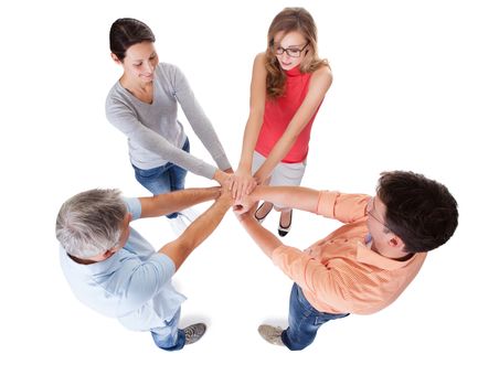 High angle conceptual teamwork and cooperation image of four casual middle-aged friends isolated on white