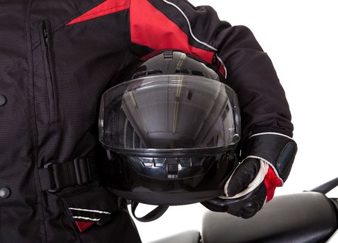 Smiling young man in protective gear holding a helmet under his arm with his red motorbike on a white studio background