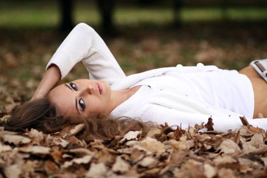 beautiful girl lies on the earth, oak leaves