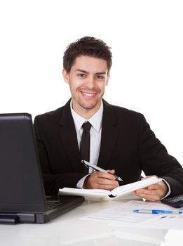 Handsome young businessman concentrating on making a note in his diary or scheduling an appointment or meeting