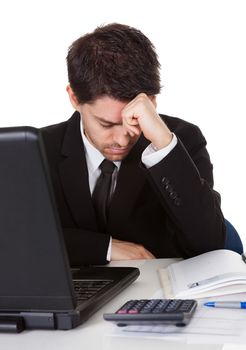 Businessman with a look of hopelessness staring at the screen of his laptop with his head resting in his hands