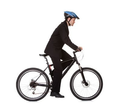 Businessman riding a bicycle to work in his suit exercising for fitness and health and to save on carbon emissions
