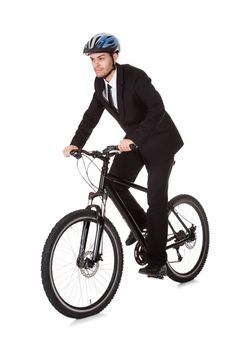 Businessman riding a bicycle to work in his suit exercising for fitness and health and to save on carbon emissions