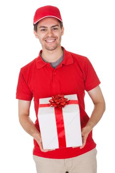 Cheerful smiling young male messenger delivering a decorative gift isolated on white
