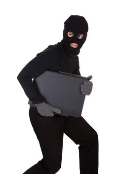 Thief dressed in black and wearing a balaclava stealing a laptop computer and making a furtive escape isolated on white
