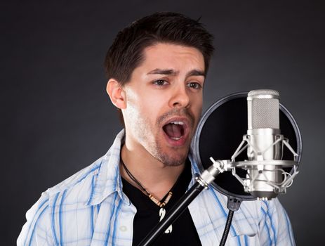 Portrait of young man singing into microphone