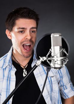 Portrait of young man singing into microphone