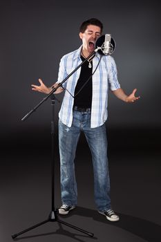 Portrait of young man singing into microphone