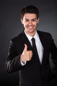 Portrait of smiling businessman over black background