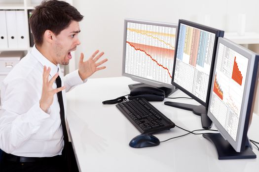 Worried stock broker looking at stock charts going down