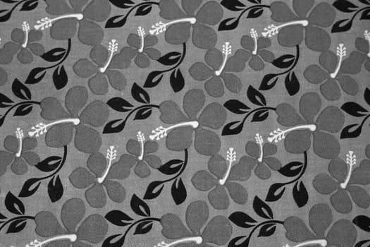 Grey flowers and black leaves on a textil background.