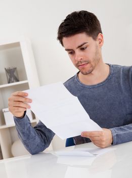 Exultant young man cheering at good news he has just received in a document that he is reading