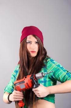 portrait of young woman holding a power tool