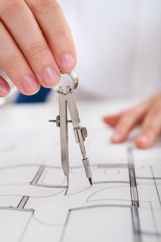 Closeup cropped image of a young male architect working on blueprints spread out on a table