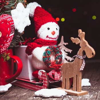 Knitted snowman on the sledges and gift box