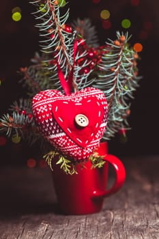 Handmade knitted heart - christmas decoration on the fir branch