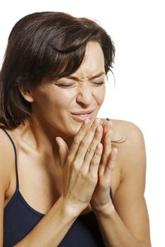 Young woman sneezing into her hands