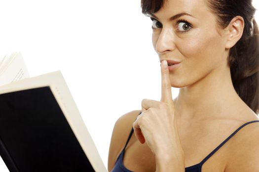 Young woman reading a book holding her finger over her mouth for quiet