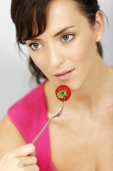 Young woman eating fresh strawberries