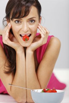 Young woman eating fresh strawberries