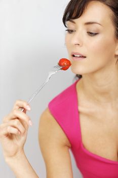 Young woman eating fresh strawberries