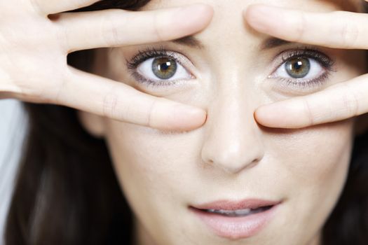 Young woman dancing and covering eyes with fingers