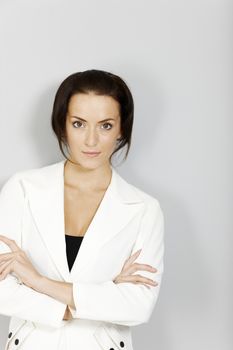 Young business woman in white suit looking serious.