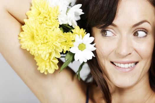 Woman holding flowers next to her head.