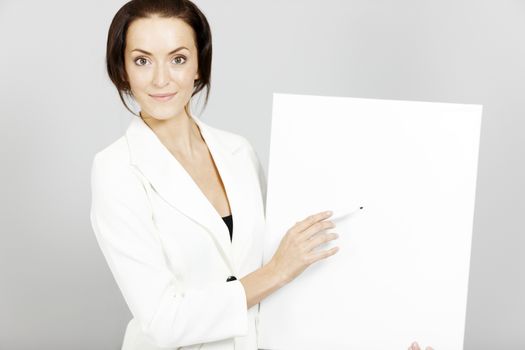 Business woman holding a wipe board during a presentation.