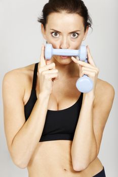 Woman holding weights by her face