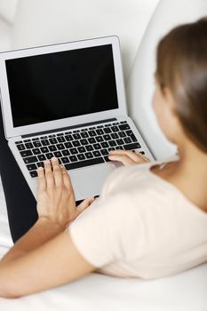 Young woman using her laptop computer at home