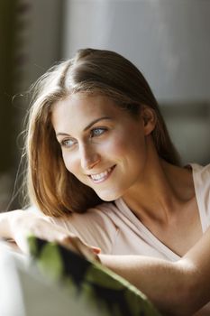 Young woman relaxing on sofa looking out of window.