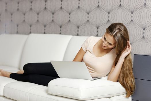 Young woman using her laptop computer at home