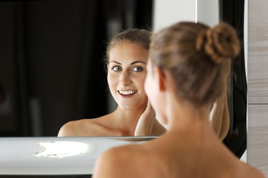 Attractive young woman in her bathroom getting ready.