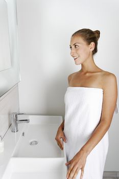 Attractive young woman in her bathroom getting ready.