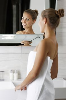 Attractive young woman in her bathroom getting ready.