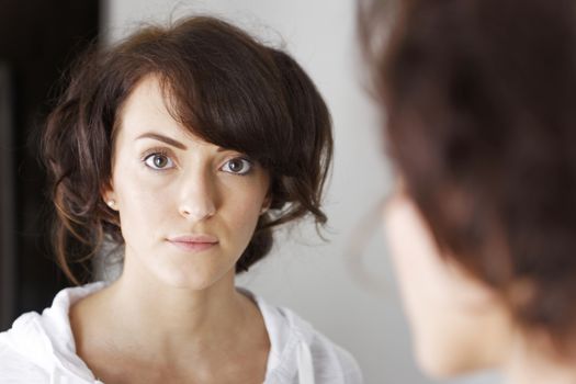 Beautiful young woman's reflection in mirror.