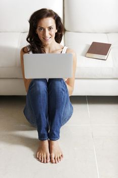 Beautiful young woman using her laptop at home.