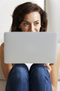 Beautiful young woman using her laptop at home.